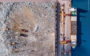 Waste loading at port cargo ship transports of garbage for recycling factory. Concept plastic Pollution environment, aerial top view