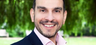 Image of Professor Ioannis Ioannou standing in front of free smiling