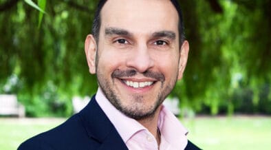 Image of Professor Ioannis Ioannou standing in front of free smiling