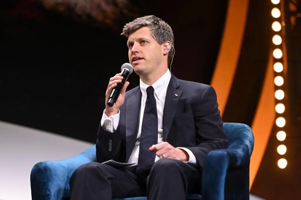 Michael Sheldrick sitzt bei einer Veranstaltung von Global Citizen auf einem blauen Stuhl in der Mitte der Bühne.